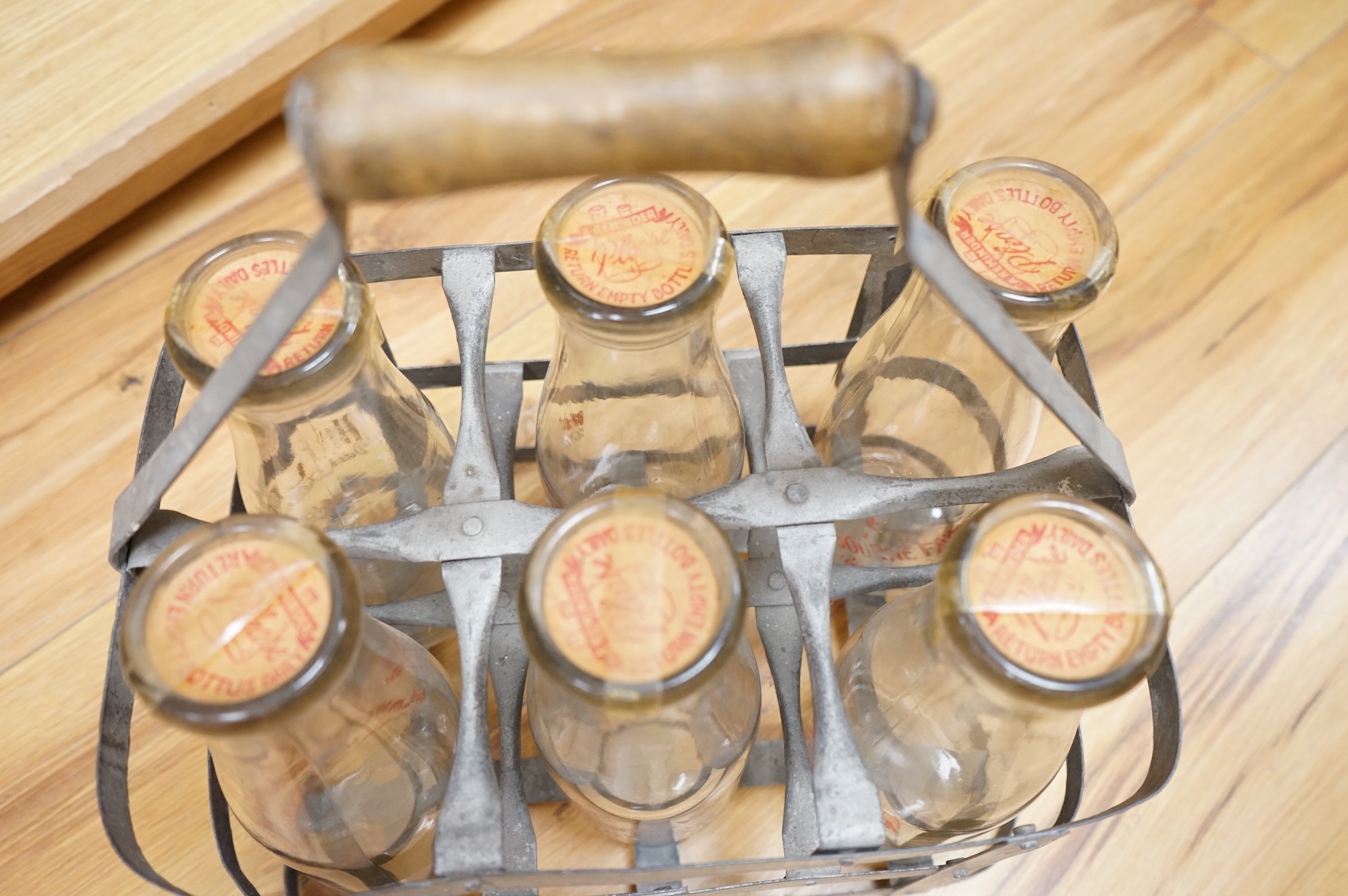 A vintage metal crate of six H J Lee, Horsham milk bottles
